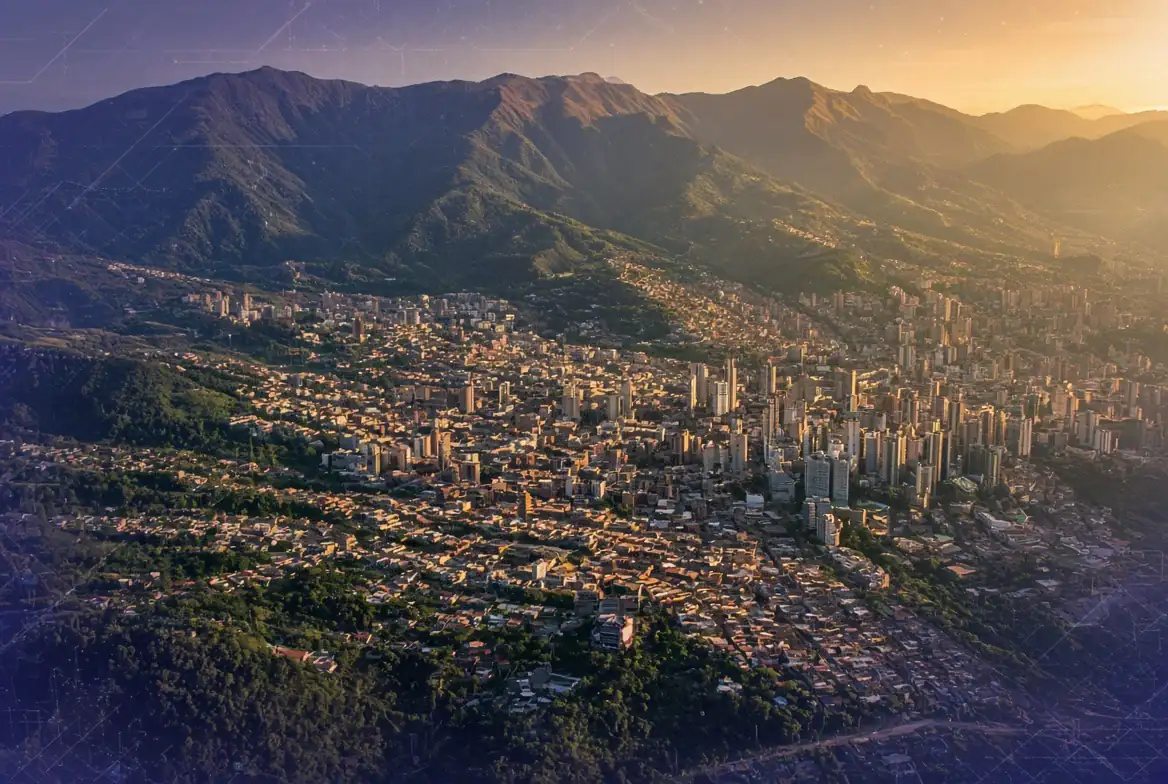 Aerial view of Medellín's dense city and hills at sunset under golden light